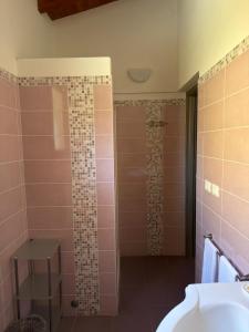 ein Badezimmer mit Waschbecken und Dusche mit rosa Fliesen in der Unterkunft Samarcanda Hotel & Parking di Parmigiani Silvia in Civitavecchia