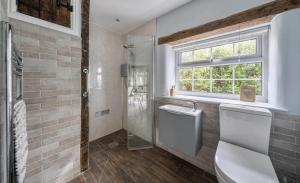 a bathroom with a shower and a sink and a window at Old Weavers in Corsley