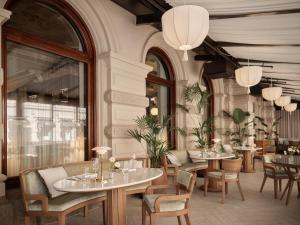 a restaurant with tables and chairs in a room at Hotel Kämp in Helsinki