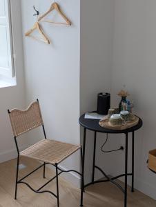a table and a chair in a room at Chambres au vert - Proche aéroport et Nantes in Saint-Aignan-Grand-Lieu