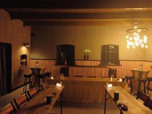 a restaurant with wooden tables and chairs and a chandelier at De Sarrieshut in Houwerzijl +14 photos