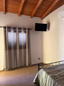 ein Schlafzimmer mit Bett und Flachbildfernseher in der Unterkunft Samarcanda Hotel & Parking di Parmigiani Silvia in Civitavecchia