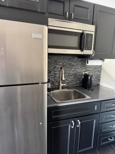 a kitchen with a stainless steel refrigerator and a sink at The Sandusky Melrose - Next to the Cedar Point Sports Center and Sports Force! Recently Renovated! in Sandusky