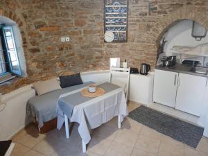a room with a bed and a table and a kitchen at The Windmill in Symi