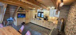 a kitchen with a table and chairs in a cabin at Farma pod Skalkou in Heľpa