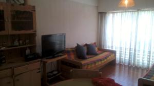 a living room with a couch and a television at Arco Iris in Miramar