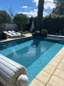 a swimming pool with blue water in a yard at Le Cottage in Saint-Jean-de-Bournay