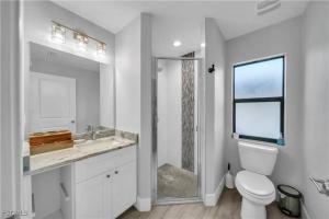 a white bathroom with a toilet and a sink at Southwest Florida Paradise in Cape Coral +11 photos