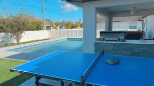 a blue ping pong table in a backyard with a pool at Southwest Florida Paradise in Cape Coral