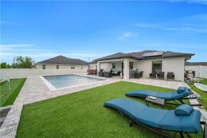 a backyard with a swimming pool and a house at Southwest Florida Paradise in Cape Coral