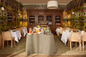 a restaurant with white tables and chairs and a table with food at Hotel des Orfèvres in Paris