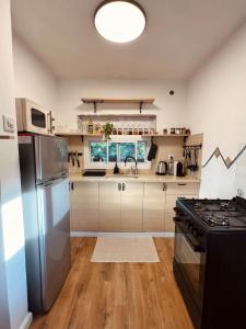 a kitchen with a stainless steel refrigerator and a stove at צימרים בצפון - אדם אדמה in Sheʼar Yashuv