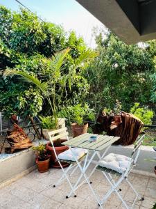 a table and chairs on a patio with plants at צימרים בצפון - אדם אדמה in Sheʼar Yashuv