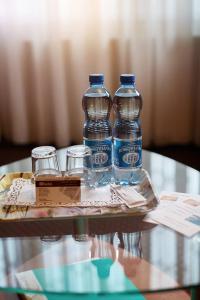two bottles of water and two glasses on a table at Hotel Włókniarz in Pabianice