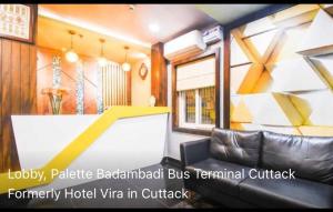 a train room with a couch and a wall at Hotel Vira in Cuttack