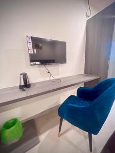 a desk with a tv and a blue chair at Hotel Vira in Cuttack