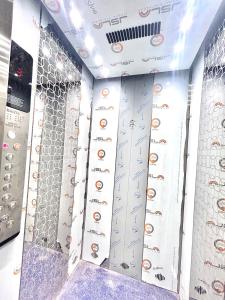 a shower in a bathroom with a wall of controls at Hotel Vira in Cuttack