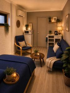 a living room with a blue couch and a table at Garden Studio with Private Patio in Wentworth Falls