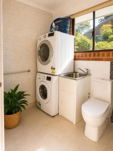 a bathroom with a washing machine and a sink at Garden Studio with Private Patio in Wentworth Falls
