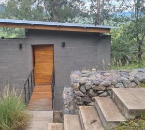 a building with a wooden door and a stone wall at Loft La Misión in Salta