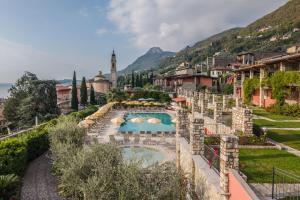 a resort with a swimming pool and a mountain at Residence Borgo Dei Limoni - Appartamenti con Garage in Gargnano