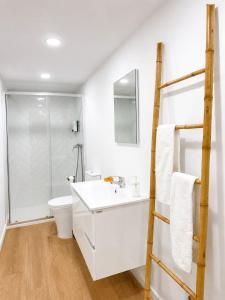 a bathroom with a white sink and a shower at Casa Trainêra in Nazaré