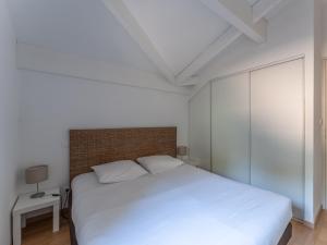 a bedroom with a white bed and a brick wall at Vacancéole - Les Rives du Lac in Lacanau +66 photos
