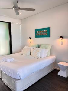 a bedroom with a large bed with white sheets at Esperance Waterfront Apartment in Esperance