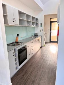 a kitchen with white cabinets and a wooden floor at Esperance Waterfront Apartment in Esperance