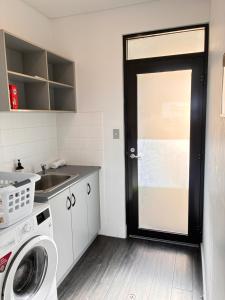 a kitchen with a black door and a sink at Esperance Waterfront Apartment in Esperance +4 photos