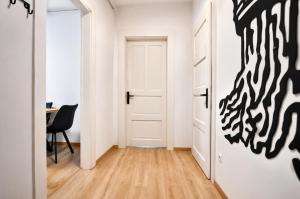 a hallway with a door leading into a room with a table at Luxurious & Spacious Residence in the Heart of Brașov in Braşov