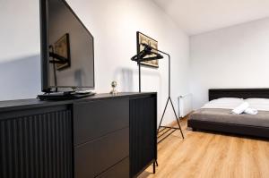 a bedroom with a bed and a dresser with a television at Luxurious & Spacious Residence in the Heart of Brașov in Braşov