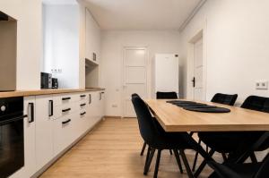 a kitchen with a wooden table and black chairs at Luxurious & Spacious Residence in the Heart of Brașov in Braşov