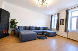 a living room with a blue couch and a table at Luxurious & Spacious Residence in the Heart of Brașov in Braşov +3 photos
