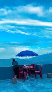 a table and chairs under an umbrella on a balcony at Lemon Tree Homestay Darjeeling in Darjeeling +15 photos