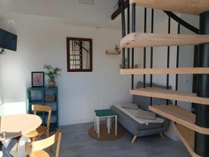 a living room with a staircase and a chair and a table at Studio cosy entre terre et mer in Saint-Alban