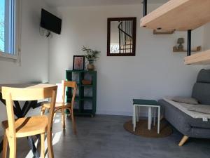 a living room with a couch and a table and chairs at Studio cosy entre terre et mer in Saint-Alban +3 photos