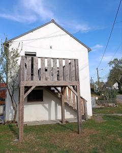 a large wooden structure in front of a building at Studio cosy entre terre et mer in Saint-Alban
