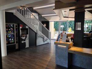 a restaurant with a staircase and a counter with a bar at Ibis Budget Agen in Le Passage