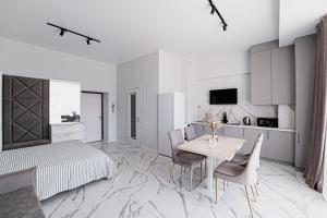 a bedroom with a bed and a table and chairs at Five Seasons apartments in Odesa