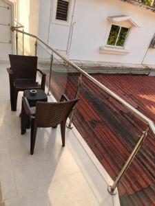 a balcony with a chair and a table and a rug at Aurevia Stays - 400m from beach in Calangute