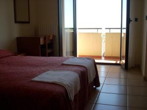 una camera con un letto e una grande finestra di Hotel Margherita a San Giovanni Rotondo