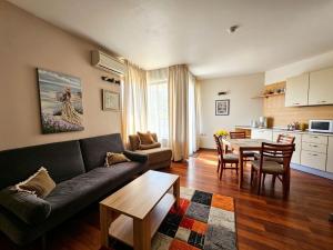 a living room with a couch and a table at Europroperties Zlatna Kotva Apartments in Golden Sands