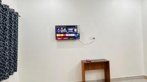 a wall with a tv on a white wall at Shreevanya Inn in Ayodhya