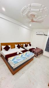 a bedroom with two beds and a chandelier at Shreevanya Inn in Ayodhya +14 photos