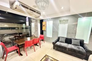 a dining room with a couch and a table and chairs at P ratunam Residence Hotel in Bangkok