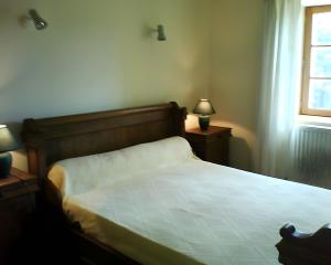a bedroom with a bed and two night stands with lamps at Gite Les Bannes in Saint-Sauves- dʼAuvergne +5 photos