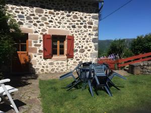 two chairs and a table in front of a building at Gite Les Bannes in Saint-Sauves- dʼAuvergne