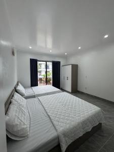 a large bedroom with two beds and a window at Dũng Đậu Homestay in Hai Phong
