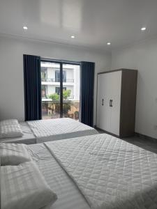 a bedroom with a large bed and a large window at Dũng Đậu Homestay in Hai Phong
